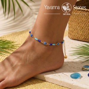 May include: A gold-tone chain anklet featuring alternating small blue and light blue beads and flat, oval-shaped evil eye charms with blue, white, and black centers. The anklet includes a short extender chain with a small round gold-tone charm.