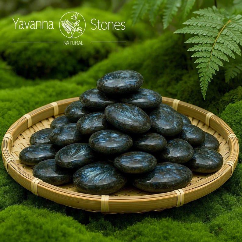 May include: A selection of smooth, oval stones with shimmering blue and green patterns, presented in a woven bamboo basket. The stones are set on green moss, with the text "Yavanna Stones NATURAL" visible in the background.
