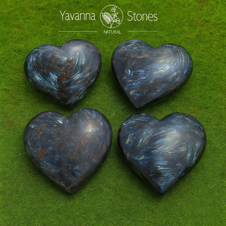 May include: Four heart-shaped stones with a dark blue and teal swirling pattern. The stones are arranged on a green surface. The text "Yavanna Stones NATURAL" is at the top of the image.