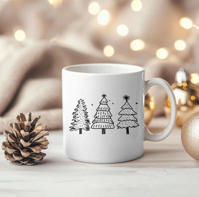 May include: White ceramic mug featuring three black line-drawn Christmas trees. The trees have varying designs, with one featuring a dotted pattern, another with horizontal lines, and the last with a layered look. The mug has a curved handle.