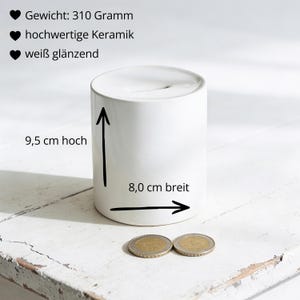 Puede incluir: Un cilindro de cer&aacute;mica blanco, de 9,5 cm de alto y 8,0 cm de ancho, con un acabado brillante. El texto de la imagen indica un peso de 310 gramos. Dos monedas en primer plano.