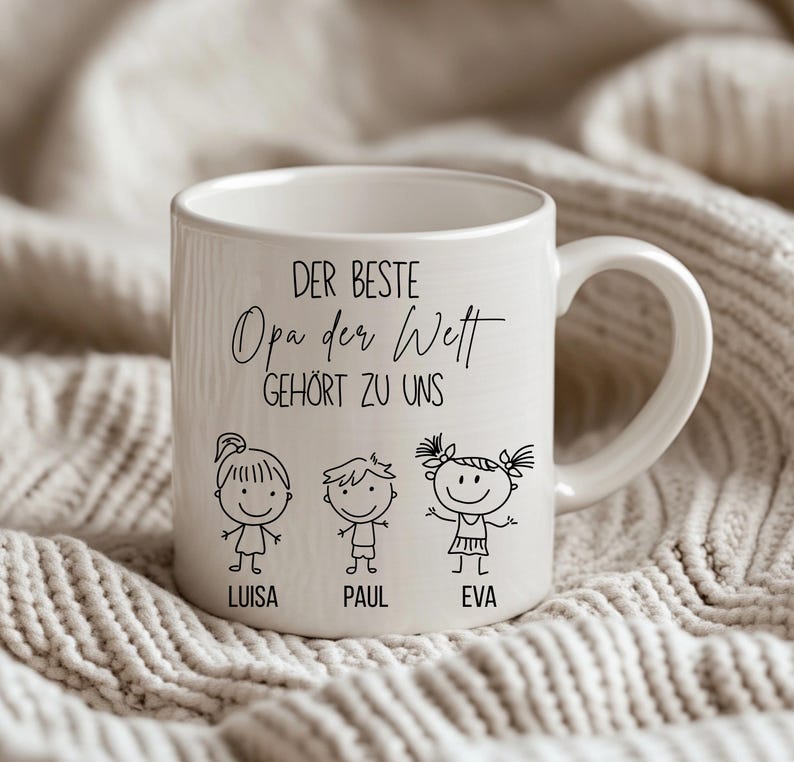 May include: White ceramic mug with a handle, featuring the text "DER BESTE Opa der Welt GEH&Ouml;RT ZU UNS" and three stick figure children with the names Luisa, Paul, and Eva. The mug is on a textured, off-white surface.
