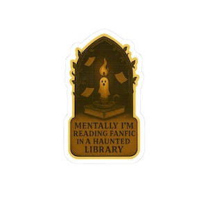 May include: A sticker featuring a candle with a ghost-like face, atop an open book, inside an arched window frame. The text reads "MENTALLY I'M READING FANFIC IN A HAUNTED LIBRARY". The design is in shades of brown and yellow.