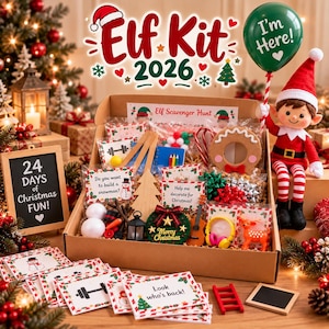 May include: A cardboard box filled with Christmas-themed elf activity supplies, including small cards, a wooden tree, a miniature wreath, a toy guitar, and a plush elf holding a green balloon that says I'm Here. The box features text reading Elf Kit 2026.