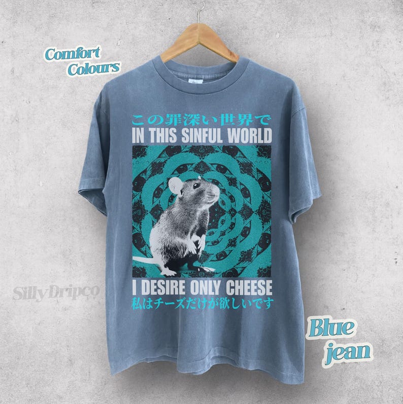 Op de afbeelding: Blauw spijkerbroek T-shirt met een rattenafbeelding en de tekst "IN THIS SINFUL WORLD" en "I DESIRE ONLY CHEESE". Het ontwerp heeft een turquoise en zwart cirkelvormig patroon. Het shirt is een comfortkleur.