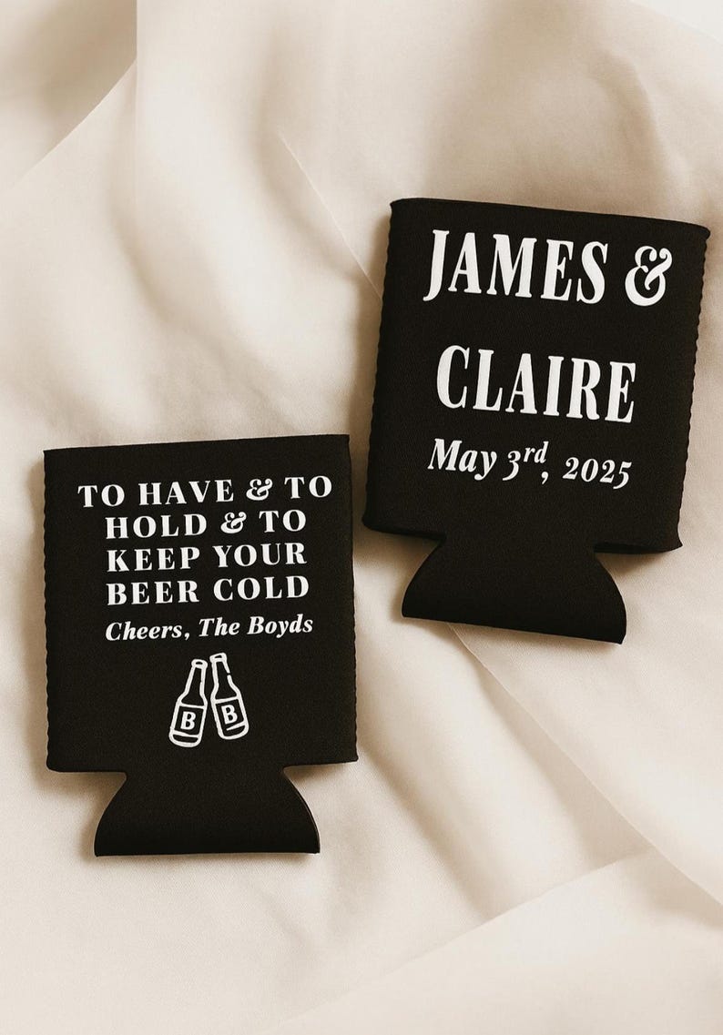 May include: Two black beer can coolers with white text. One says "TO HAVE & TO HOLD & TO KEEP YOUR BEER COLD Cheers, The Boyds" with beer bottle graphics. The other says "JAMES & CLAIRE May 3rd, 2025".