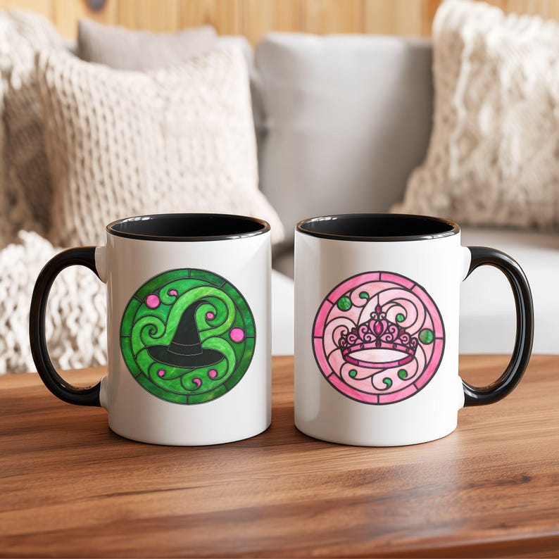 Pu&ograve; includere: Due tazze in ceramica bianca con manici e bordi neri. Una tazza presenta un design a cappello da strega verde e nero, l'altra una corona rosa. Entrambi i disegni sono in uno stile circolare a vetrata.