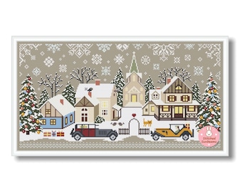 Op de afbeelding: Kruissteekpatroon van een winterdorp met besneeuwde huizen, een kerk en kerstbomen. Twee oldtimers staan ​​geparkeerd voor de huizen. De achtergrond is lichtgrijs met sneeuwvlokpatronen. De afbeelding is wit omlijst.