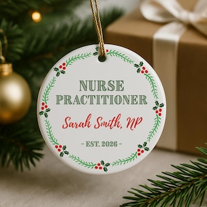May include: White ceramic Nurse Practitioner ornament with green text and a red floral border. The ornament includes the name "Sarah Smith, NP" and the establishment year "EST. 2026". A gold string is attached for hanging.