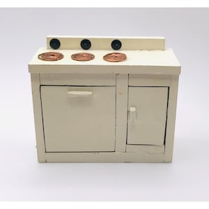 May include: White miniature stove with three copper burner elements and two doors. The stove has a white painted finish and black knobs.