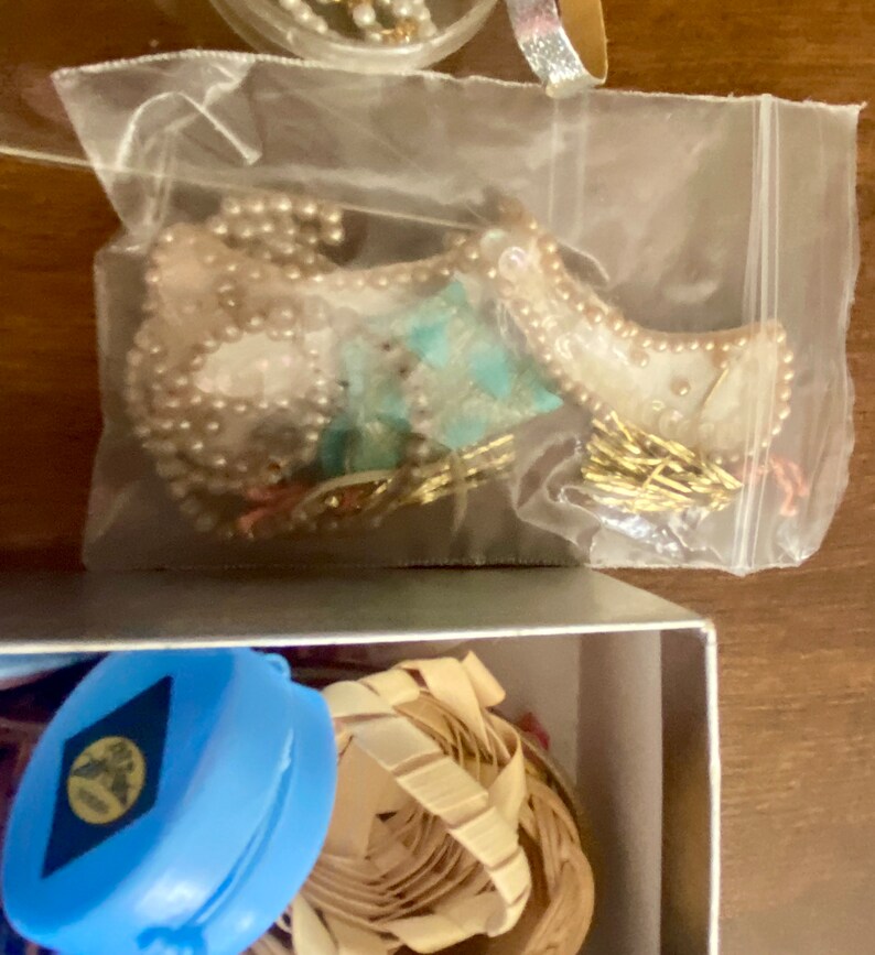 Op de afbeelding: Een doorzichtige plastic zak gevuld met verschillende sieraden, waaronder een parelketting, een turquoise en gouden hanger en een gouden ketting.