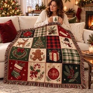 May include: A woven throw blanket featuring a grid of Christmas-themed squares, including a reindeer, snowman, gingerbread man, candy cane, stocking, gift, wreath, ornament, and pine branches, finished with a fringed edge on all sides.