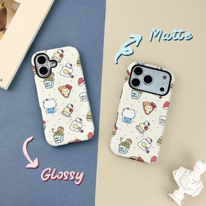 May include: Two phone cases with a repeating pattern of Hello Kitty characters and food items like pizza and popcorn. One case is labeled "Glossy" and the other "Matte". The cases are white with a black camera lens cutout.