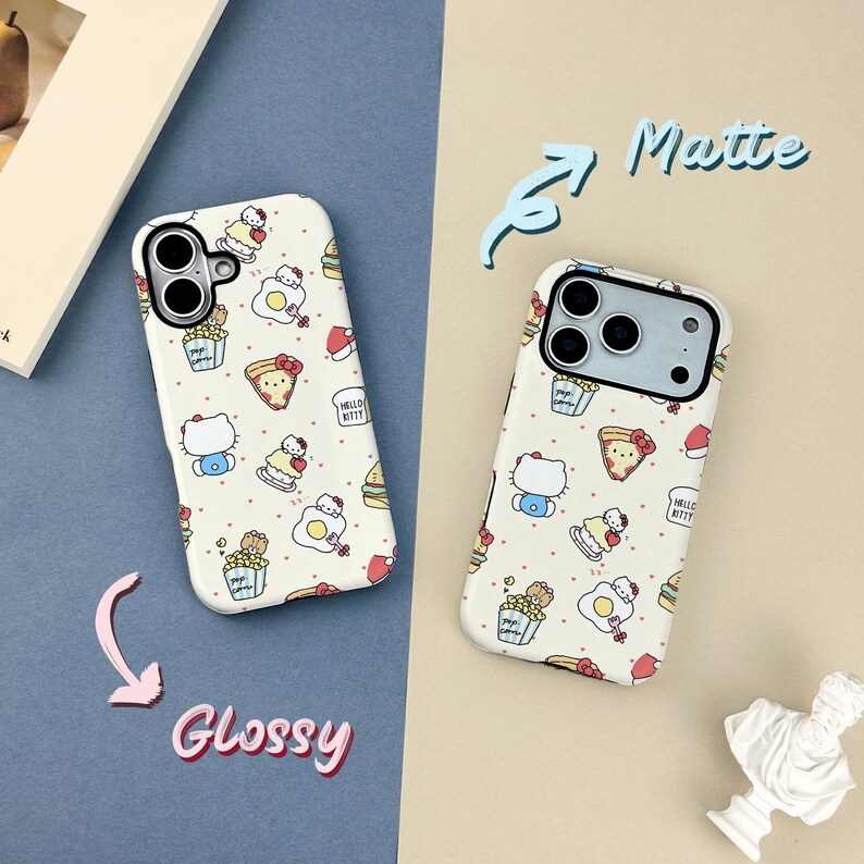 May include: Two phone cases with a repeating pattern of Hello Kitty characters and food items like pizza and popcorn. One case is labeled "Glossy" and the other "Matte". The cases are white with a black camera lens cutout.