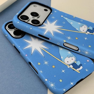 May include: Two blue phone cases with a whimsical design featuring a cartoon character in a wizard hat, holding a wand, and surrounded by stars. The cases have a black border and are designed to fit a smartphone.