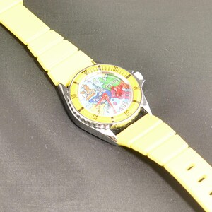 Vintage map watch featuring colorful European destinations, analog display, and whimsical airplane hand circling the dial