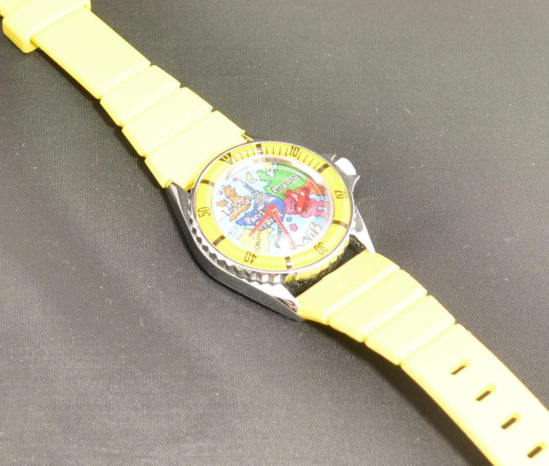Vintage map watch featuring colorful European destinations, analog display, and whimsical airplane hand circling the dial