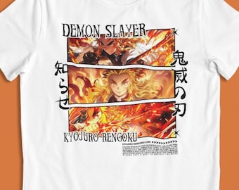 Pode incluir: Camiseta branca com um gráfico da série de anime Demon Slayer. O design inclui o texto "DEMON SLAYER" e "KYOJURO RENGOKU", juntamente com caracteres japoneses e ilustrações de personagens. A camiseta tem gola redonda e mangas curtas.