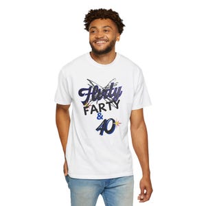 May include: White t-shirt with the text "Flirty Farty & 40" in a blue and black design. The shirt features a playful font and a starburst graphic next to the number 40.