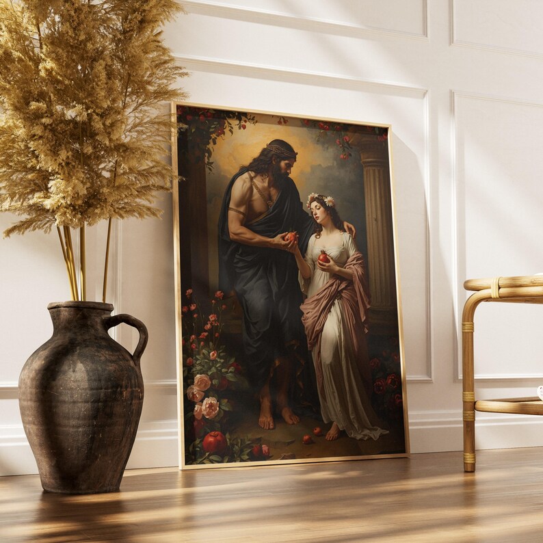 May include: A framed art print shows a classical scene of two figures, a man and a woman, in a garden. The man, in dark fabric, offers a red fruit to the woman, who wears a white gown and floral crown. The artwork is in a gold frame.