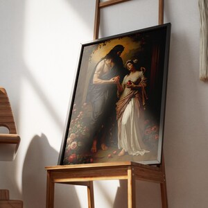 May include: Framed art print showing a classical scene with two figures, one in dark robes and the other in a white dress, surrounded by roses and apples. The artwork is displayed on a wooden stand.