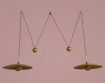 Pode incluir: Uma luminária de teto de latão com dois pingentes, apresentando duas cúpulas largas, planas e em forma de disco, suspensas por fios finos. O design inclui dois contrapesos esféricos de latão que criam um padrão geométrico em ziguezague.