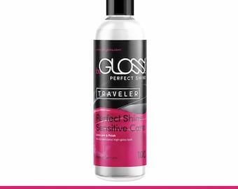 May include: A clear plastic bottle with a black cap containing beGLOSS Perfect Shine Traveler latex care and polish. The label features black and pink text, including the words Perfect Shine, Sensitive Care, and 100, with Made in Germany printed.