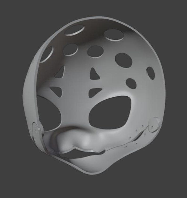 Op de afbeelding: Een grijze hockeymasker met ronde en driehoekige ventilatiegaten. Het masker heeft oog- en mondopeningen en een afgeronde vorm. Het masker is waarschijnlijk bedoeld voor kostuums of cosplay.