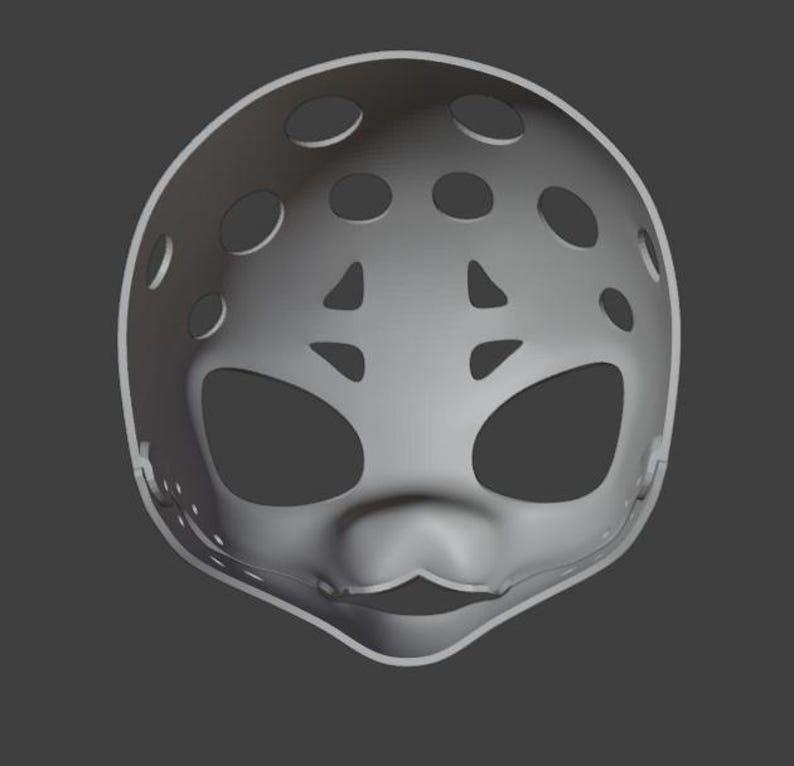 Op de afbeelding: Een grijze plastic masker met grote ovale ooggaten en talrijke cirkelvormige en driehoekige ventilatiegaten. Het masker heeft een afgeronde vorm met een gedefinieerde neus en een kleine, gebogen mondopening.