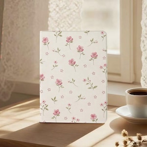 May include: A rectangular tablet case featuring a cream-colored background with a repeating pattern of small pink flowers and green stems. The design covers the entire front surface of the case, which is positioned upright on a flat surface.