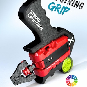 Op de afbeelding: Een zwart en rode string launcher met de tekst "LEVEL STRING GRIP" en "STRING LAUNCHER". De launcher heeft een handvat, een rode behuizing en een waterpas. De afbeelding bevat ook een kleurenwiel en de tekst "CHOOSE YOUR COLORS".