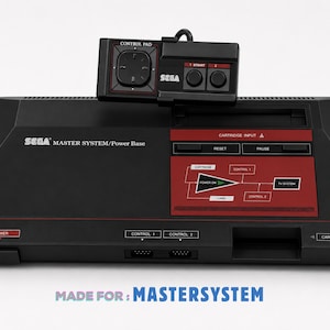 Pode incluir: Uma consola Sega Master System Power Base preta com um painel de controlo vermelho apresentando um diagrama, botões de reset e pausa, e uma entrada de cartucho. Um comando retangular preto com um pad direcional repousa no topo.