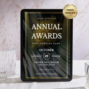 May include: An event invitation on a black tablet with gold accents. The text reads "Annual Awards" with event details for October 29th at the Grand Ballroom. A gold Canva Template sticker is in the upper right corner. Two glasses and a bottle are in the foreground.