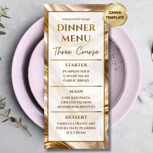 Op de afbeelding: Een goud-wit dinermenu sjabloon met de tekst "DINNER MENU" en "Three Course". Het menu bevat voorgerecht-, hoofdgerecht- en dessertopties. Een gouden vork en mes staan rechts, en een roze bord staat op de achtergrond.
