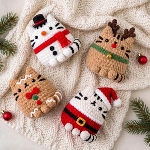 Pode incluir: Quatro peluches de gato em croché com temas festivos: um boneco de neve com cachecol vermelho, uma rena com chifres e coleira verde, um gato de gengibre com laço vermelho e um gato Pai Natal com gorro e cinto vermelho e branco.