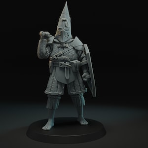 May include: A grey miniature figurine of a medieval knight, complete with a pointed helmet, armour, shield, and sword. The knight stands on a circular base, posed as if ready for battle. The details of the armour are finely sculpted.