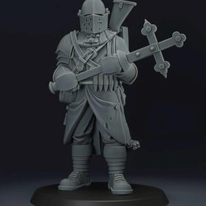 May include: A gray figurine of a medieval knight in full armor, holding a large cross and a weapon. The knight wears a helmet with a cross emblem, a long coat, and boots. The figure is standing on a black base.