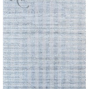 Könnte beinhalten: Hellblauer und weißer strukturierter Teppich mit geometrischem Muster. Der Teppich hat ein gewebtes Aussehen und ein verblasstes Design. Die Buchstaben "KC" sind in der oberen linken Ecke sichtbar.