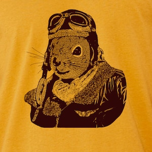 May include: A brown squirrel wearing a leather aviator helmet and goggles. The squirrel is looking to the right and has a serious expression on its face.