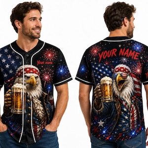 Puede incluir: Camiseta de béisbol con un diseño patriótico que presenta un águila con gafas de sol y una diadema, sosteniendo una jarra de cerveza. La camiseta tiene una base negra con ribetes blancos, la bandera estadounidense, fuegos artificiales y el texto "YOUR NAME".
