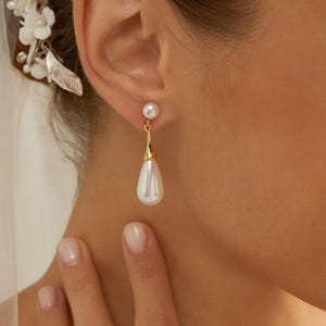 May include: Elegant pearl drop earrings with gold accents. The earrings feature a small pearl stud at the top, connected to a teardrop-shaped pearl pendant. The design is classic and sophisticated, suitable for special occasions.