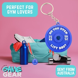 May include: A blue weight plate keyring with the text "DO YOU EVEN LIFT BRO?" and "25 KG". A blue gym bag, water bottle, and dumbbells are also visible. The image has the text "GAME GEAR" and "SENT FROM AUSTRALIA".
