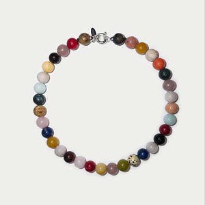 May include: A circular necklace composed of multi-colored, smooth, round gemstone beads in various shades including red, blue, yellow, green, pink, white, and black, secured with a silver-toned metal spring ring clasp.
