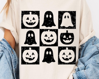 May include: Cream-colored t-shirt featuring a grid pattern of black and white Halloween-themed graphics. The design includes jack-o'-lanterns and ghost figures. The shirt has a relaxed fit and short sleeves, suitable for casual wear.