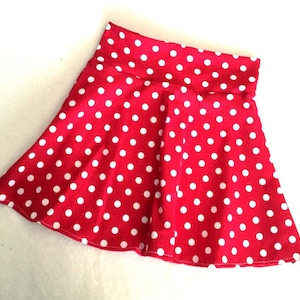 May include: A red skirt with white polka dots. The skirt is a-line and has a wide waistband.
