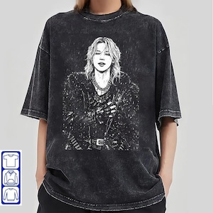 May include: Black oversized t-shirt with a black and white illustration of a person with long hair, wearing a jacket and jewellery. The shirt has a vintage, faded appearance. The design is centered on the front of the shirt.