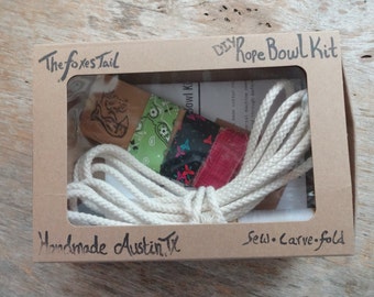 May include: A DIY rope bowl kit from The Foxes Tail, a handmade craft kit from Austin, Texas. The kit includes a length of natural cotton rope, fabric scraps in various colors and patterns, and instructions to sew, carve, and fold the rope into a bowl.