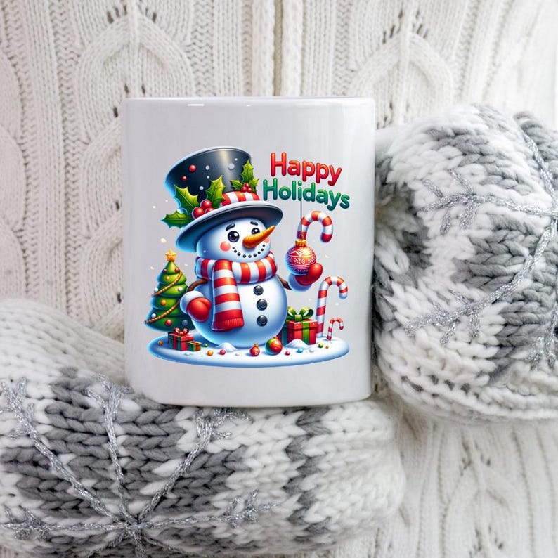 Puede incluir: Taza de cer&aacute;mica blanca con un dise&ntilde;o de mu&ntilde;eco de nieve sonriente, con sombrero de copa negro y bufanda a rayas rojas y blancas, sosteniendo un bast&oacute;n de caramelo y una bola de Navidad. La taza tiene el texto "Happy Holidays".