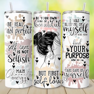 May include: Three white stainless steel tumblers with lids and straws. Each tumbler features inspirational quotes and graphics in black and pink. The quotes include "Be Real, Not Perfect", "Be Your Own Kind of Beautiful", and "I Was Sleeping on Myself".