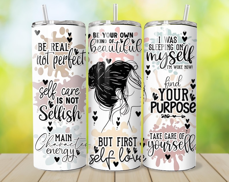 May include: Three white stainless steel tumblers with lids and straws. Each tumbler features inspirational quotes and graphics in black and pink. The quotes include "Be Real, Not Perfect", "Be Your Own Kind of Beautiful", and "I Was Sleeping on Myself".
